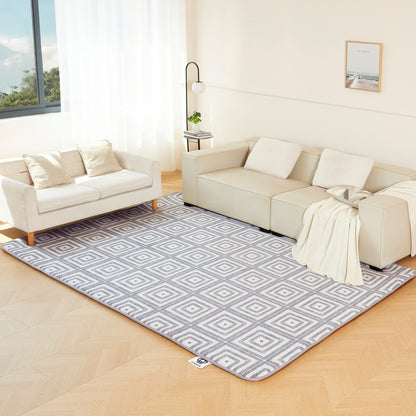 Living room with a patterned rug, beige sofa, and white walls.