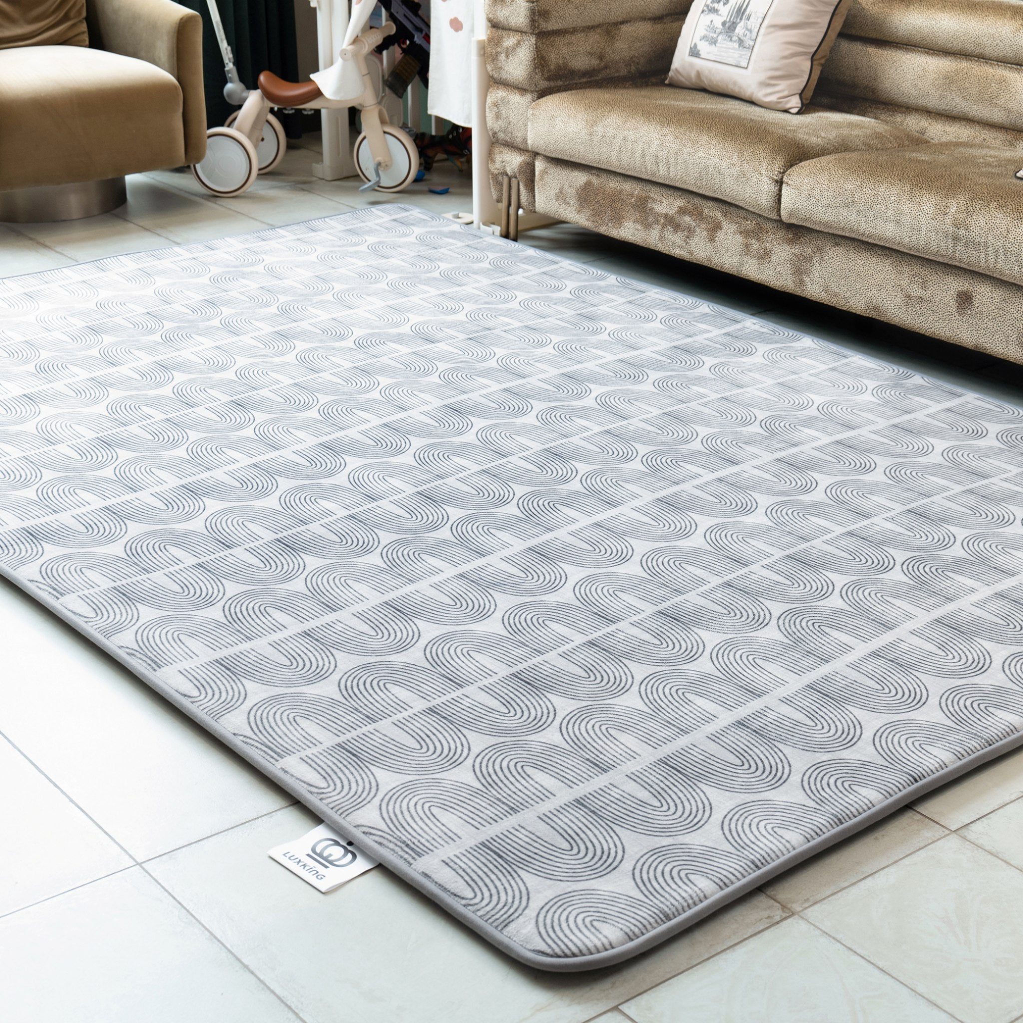 Gray patterned rug on a tiled floor in a living room setting