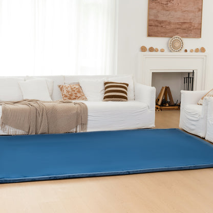 Blue mat on a wooden floor in a living room with white furniture and decor.