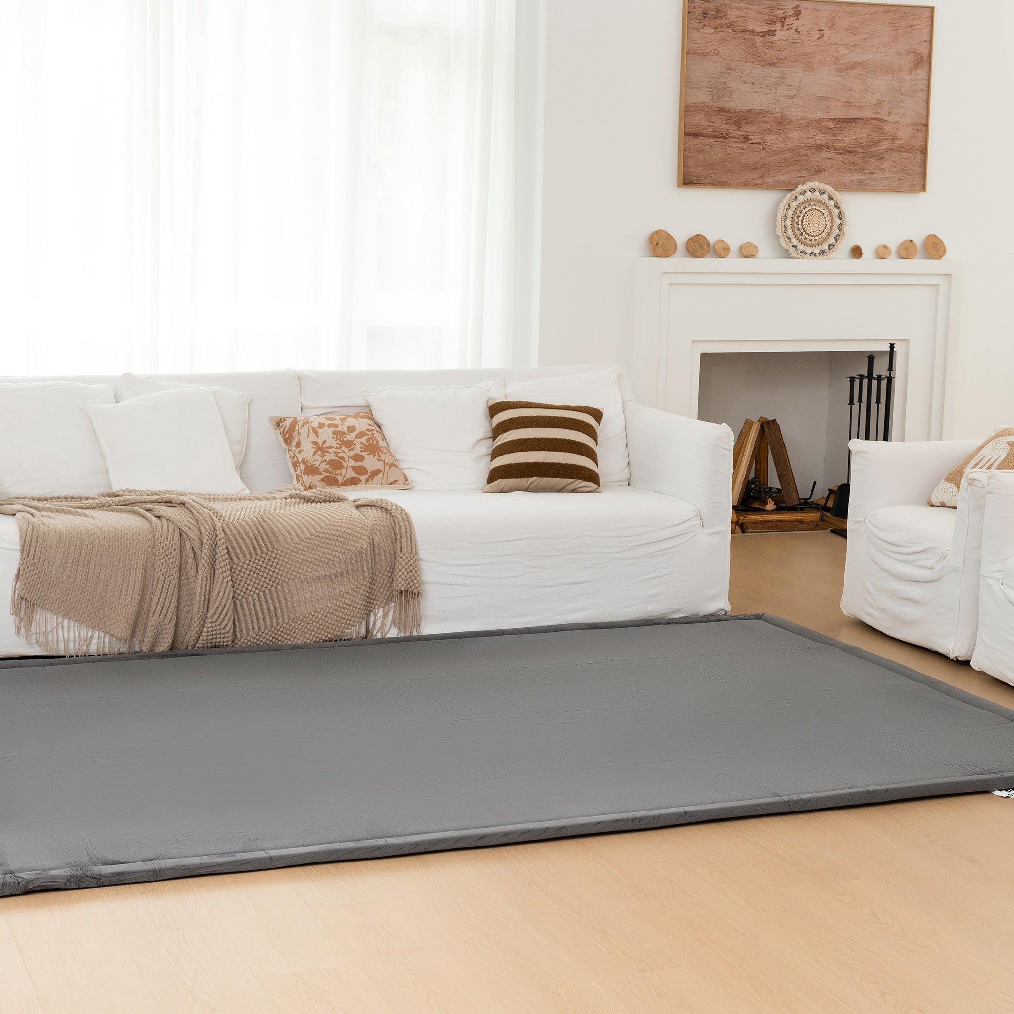 Gray pet mat in a living room with a white couch and fireplace.