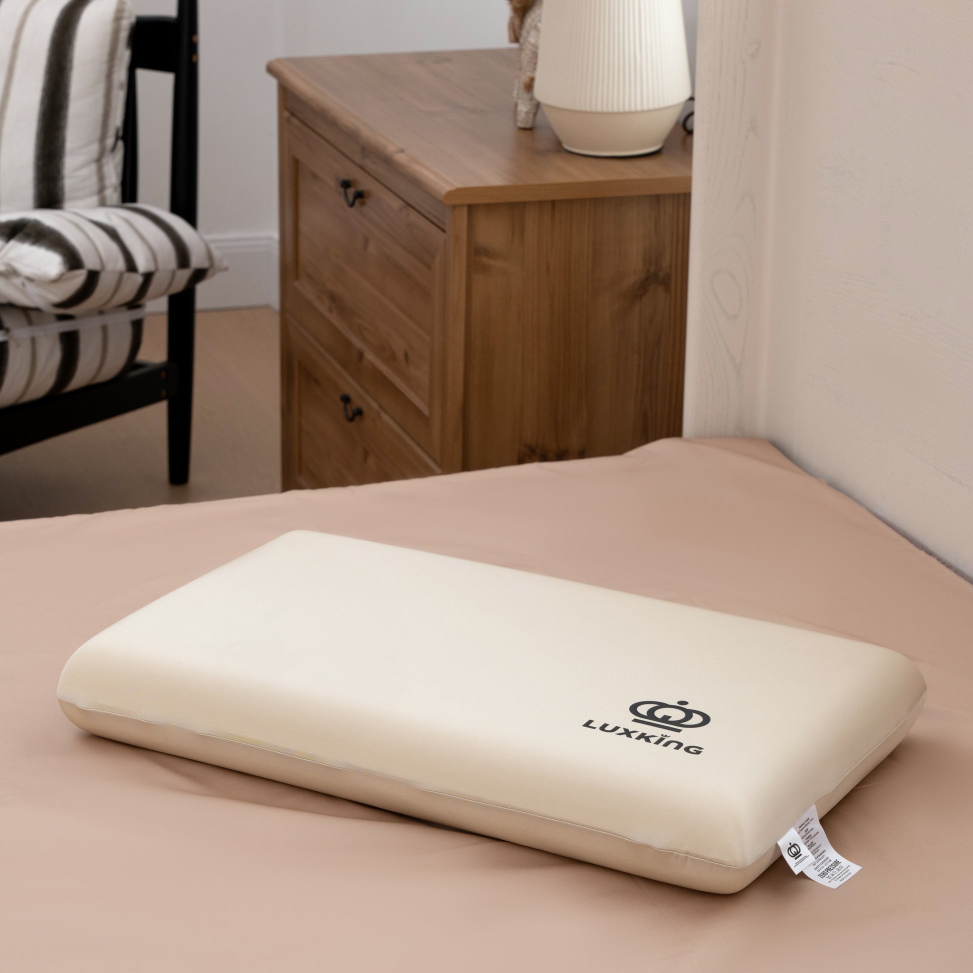 Beige pillow with Luxking logo on a bed in a bedroom setting