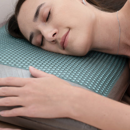 Woman lying on a textured mat with her eyes closed