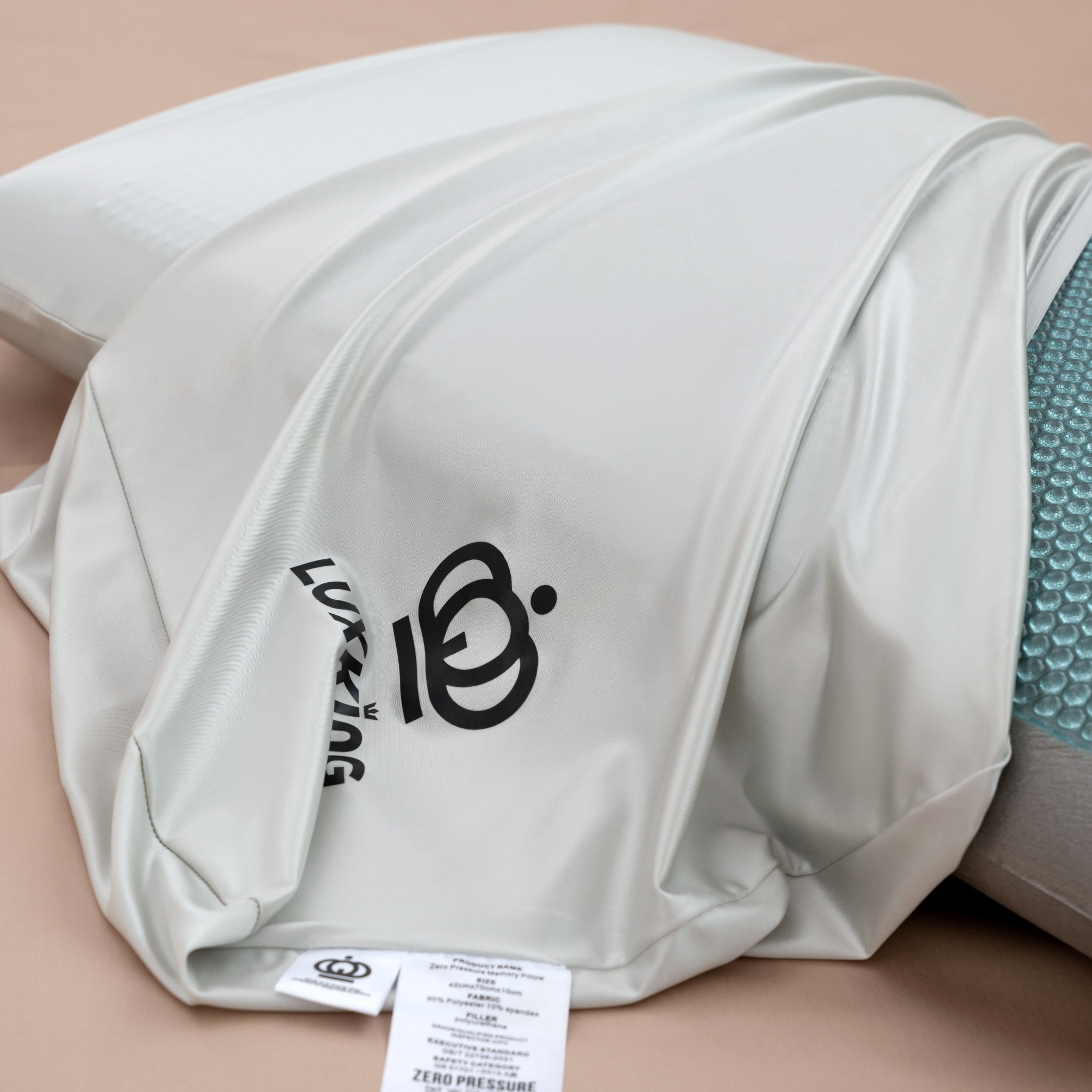 White pillow with a brand logo on a beige background