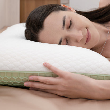 Woman lying on a white pillow with a green honeycomb pattern, smiling.