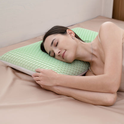 Woman sleeping on a green pillow in a bedroom setting