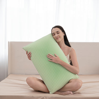 Woman holding a green pillow on a couch with a white background