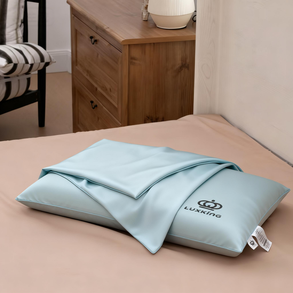 Light blue pillow with a blanket on a bed in a bedroom setting
