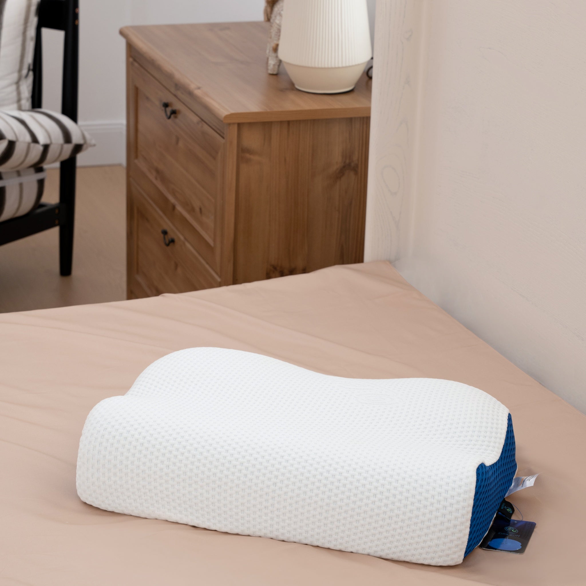 Ergonomic pillow on a bed in a bedroom setting