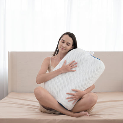 Woman holding a large white pillow on a bed