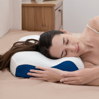 Woman lying on a bed with a white and blue pillow, wearing earphones.