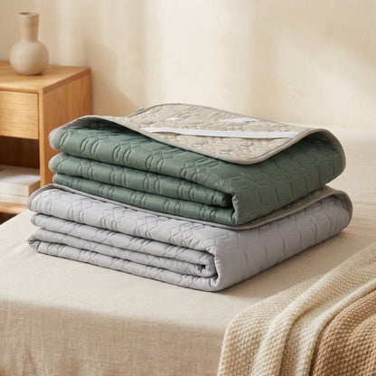 Stack of folded quilts on a bed in a bedroom setting