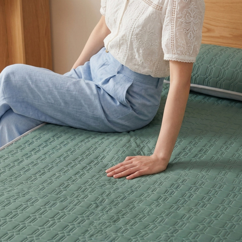 Person sitting on a textured green mattress in a bedroom setting