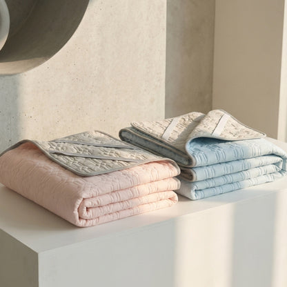Folded textured towels in pastel colors on a light surface with a neutral background