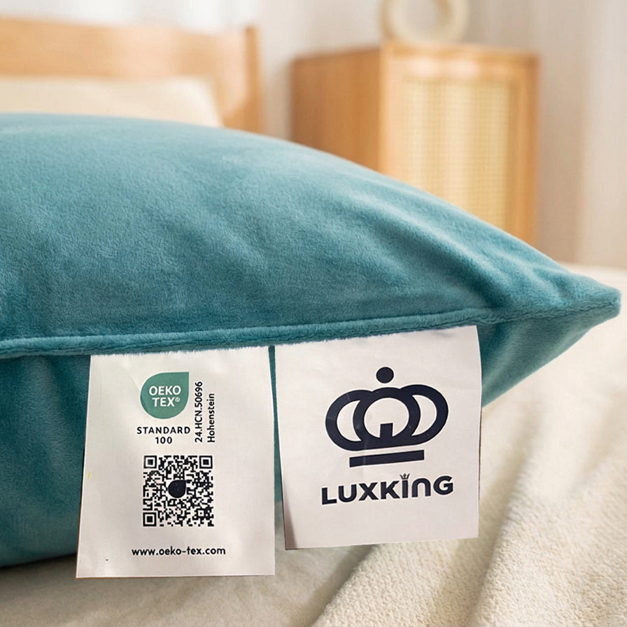 Teal pillow with Luxking label on a bed