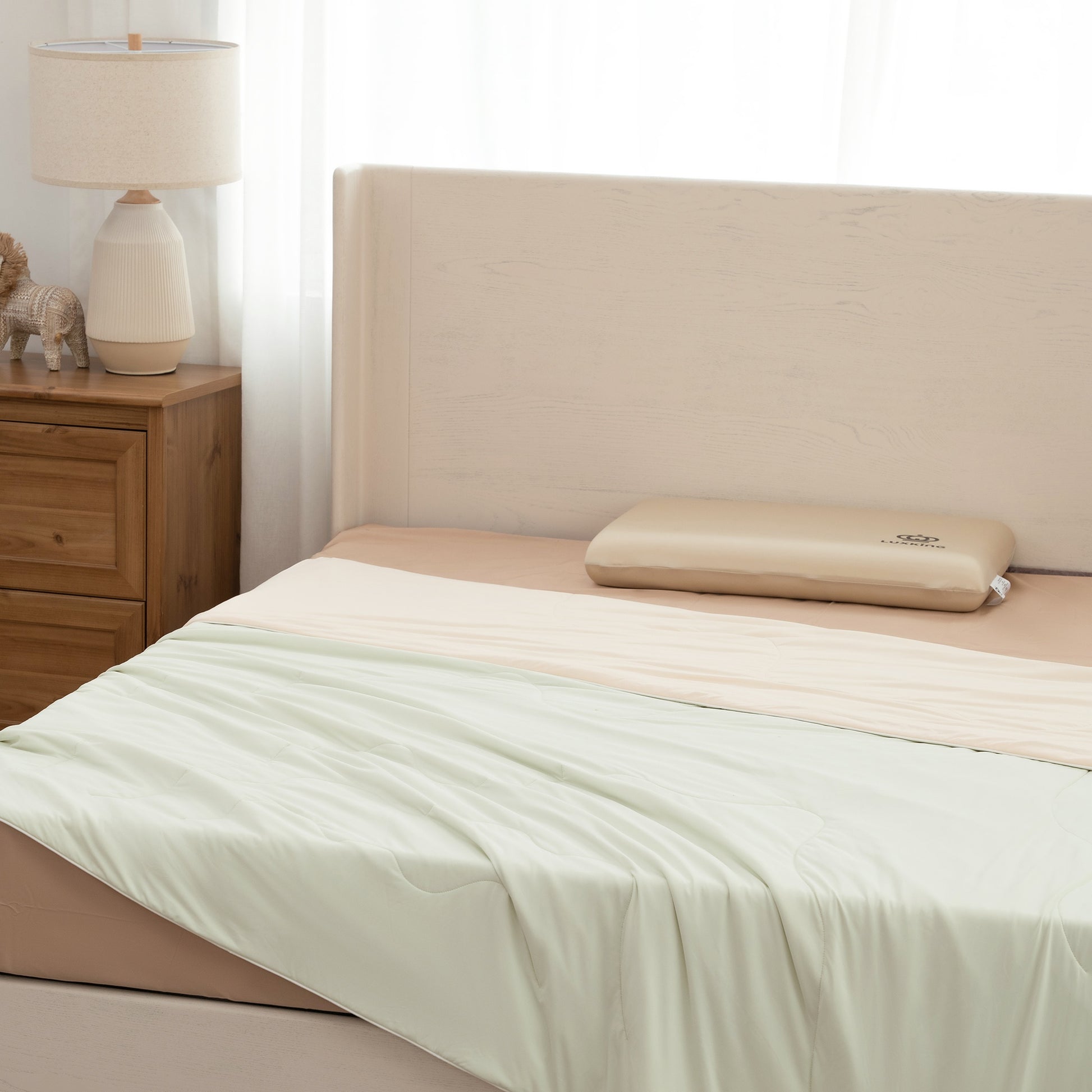 Bed with beige headboard and white bedding in a bedroom setting.