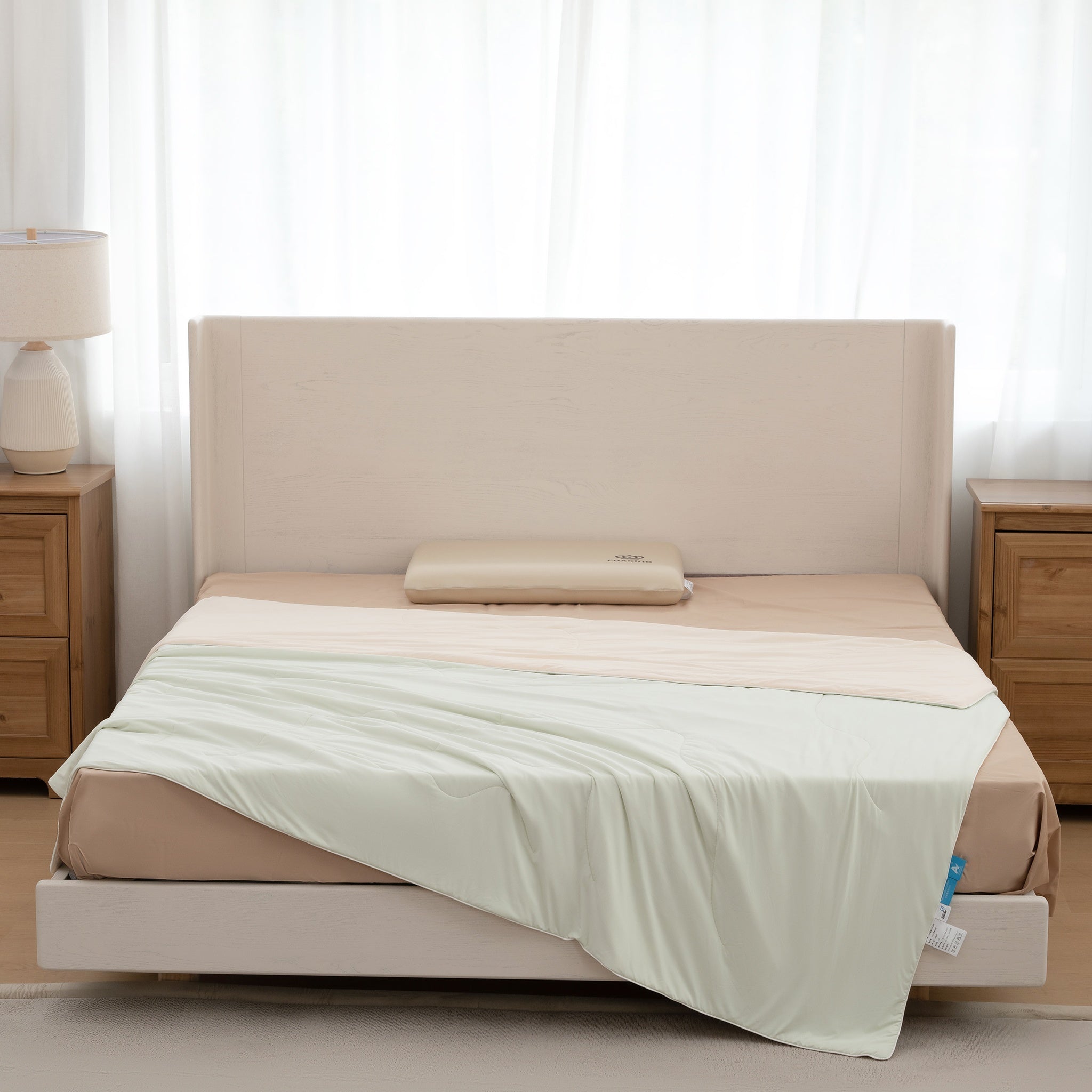 Beige bed with a white comforter in a bedroom setting