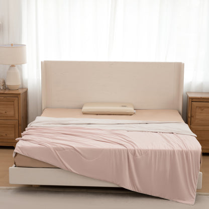Beige bed with pink bedding in a bedroom setting