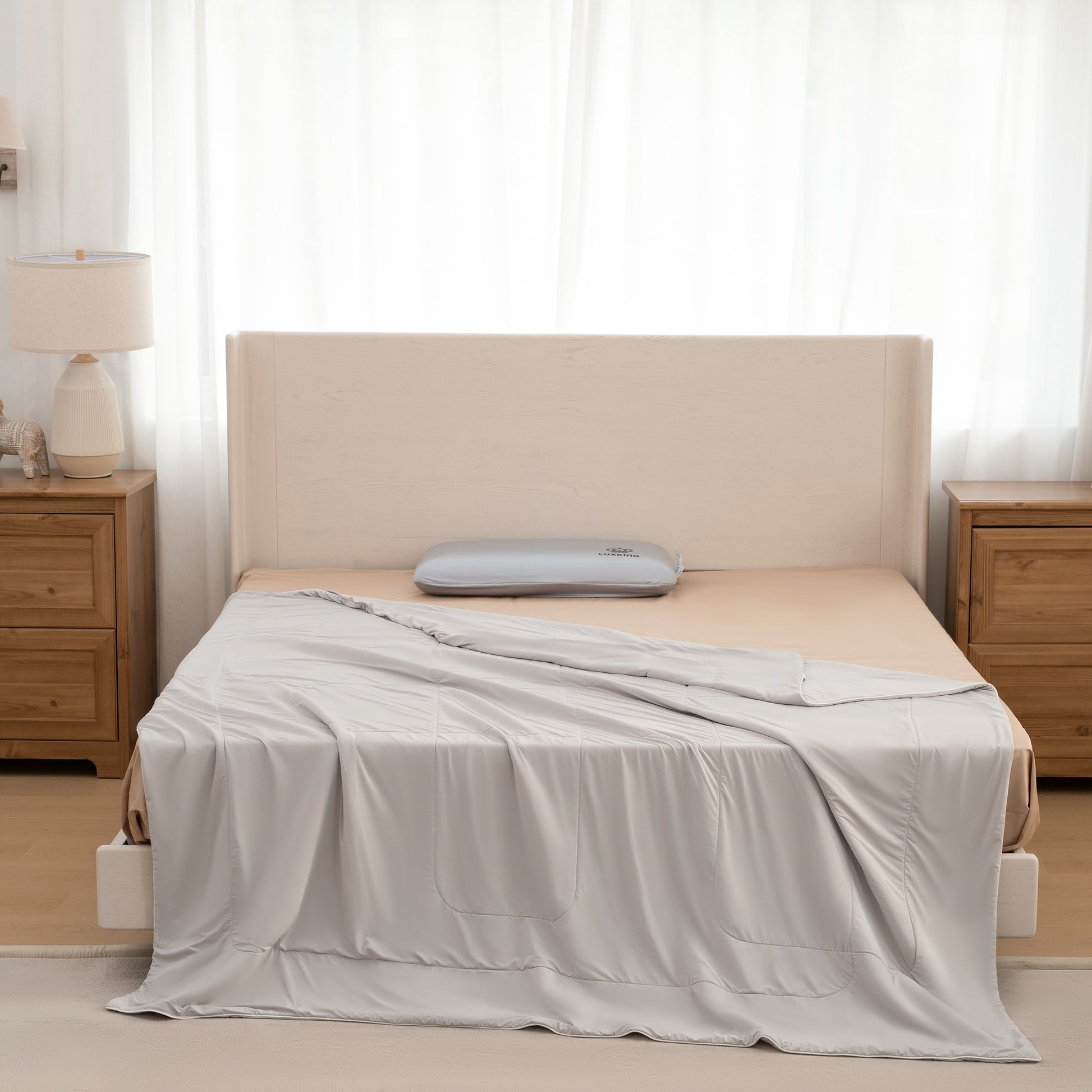 Bed with beige headboard and gray bedding in a bedroom setting